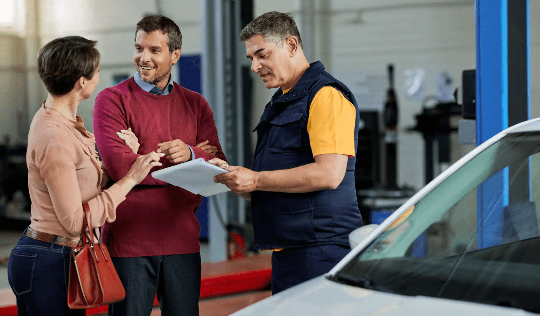 People discussing in an auto repair shop.