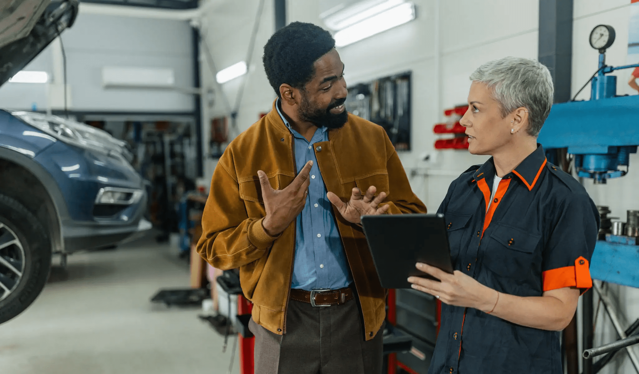 Mechanic and customer discussing car repair details.