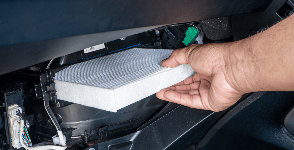 Hand replacing a car air filter