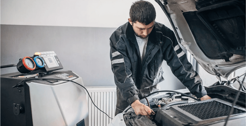 Mechanic working on car engine maintenance.
