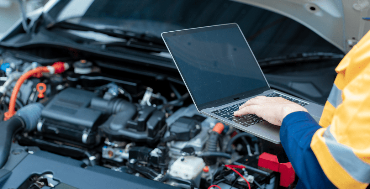 Technician analyzing engine with computer