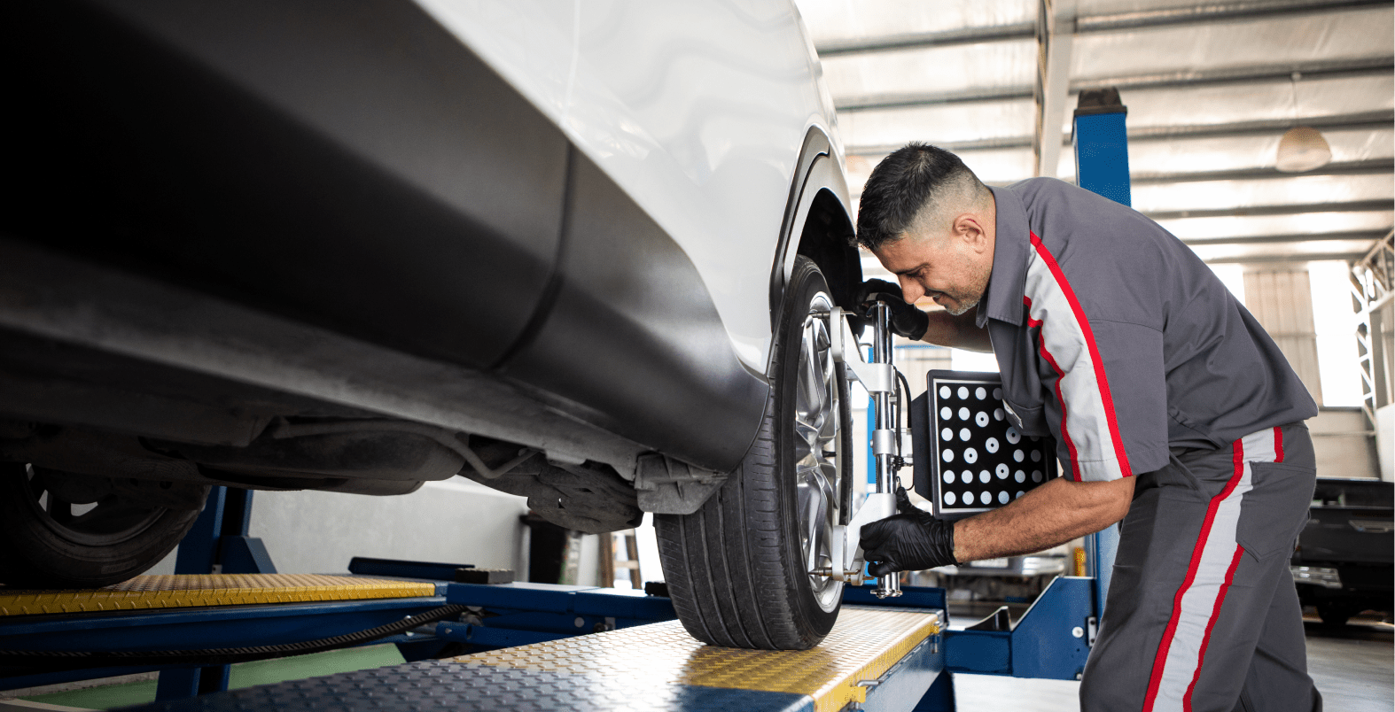 Auto repair professional working on vehicle alignment