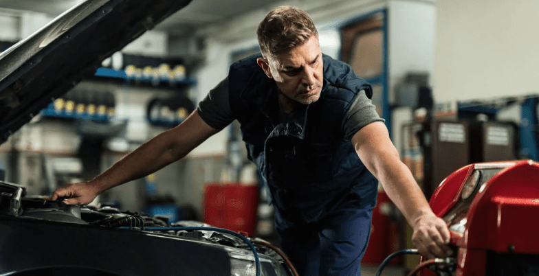 Mechanic working on car in a garage.